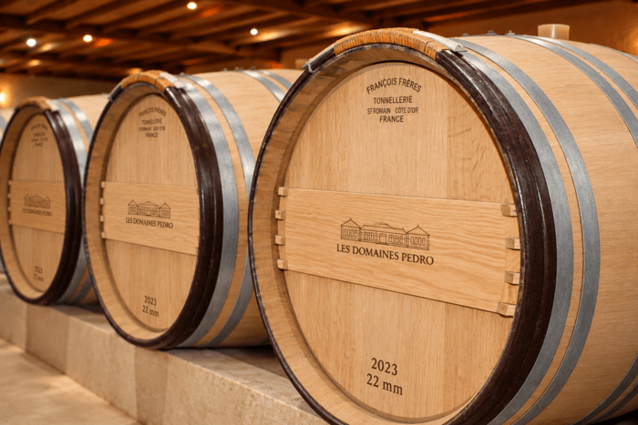 Barriques en chêne dans le chai d’élevage des Domaines Pedro, propriété viticole familiale du Médoc, produisant des vins de Haut-Médoc et de Saint-Estèphe.
