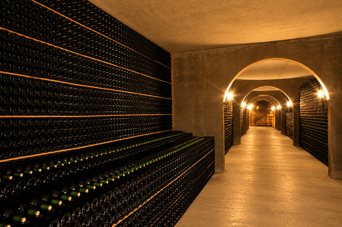 Caveau souterrain du Château Le Meynieu, avec ses rangées de bouteilles de vin soigneusement alignées au cœur du vignoble du Haut-Médoc, dans le Bordelais.