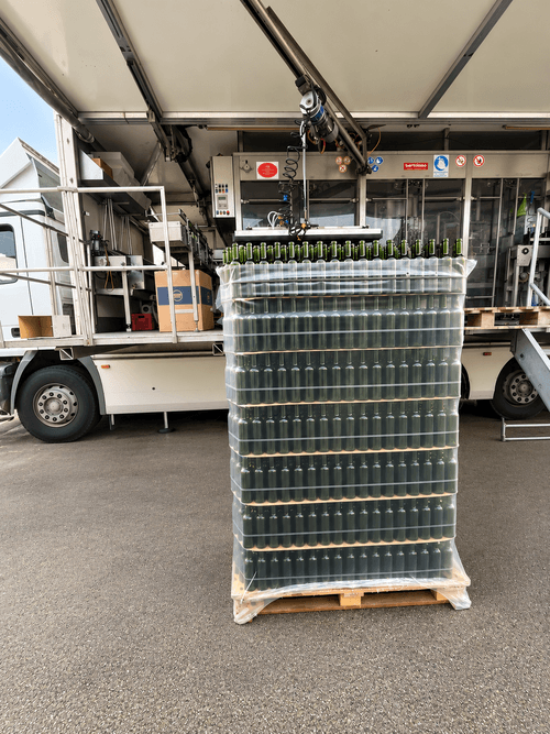 Mise en bouteille des vins des Domaines Pedro dans le Médoc, avec des bouteilles alignées sur une ligne d’embouteillage au château.